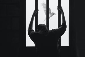 black and white photo of prisoner looking out window